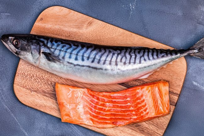 Fish and a fish filet on a cutting board