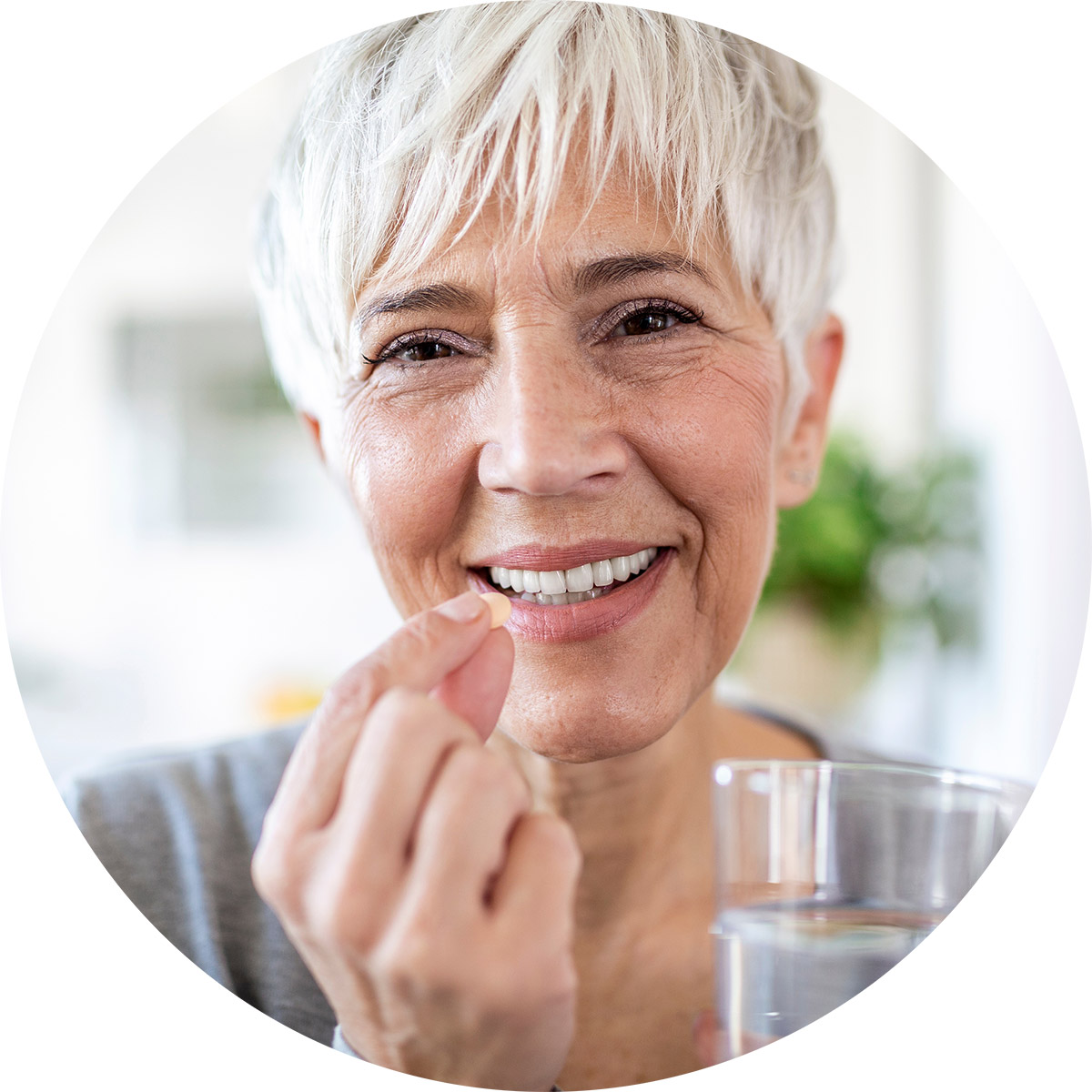 Older woman holding a vitamin supplement and a glass of water